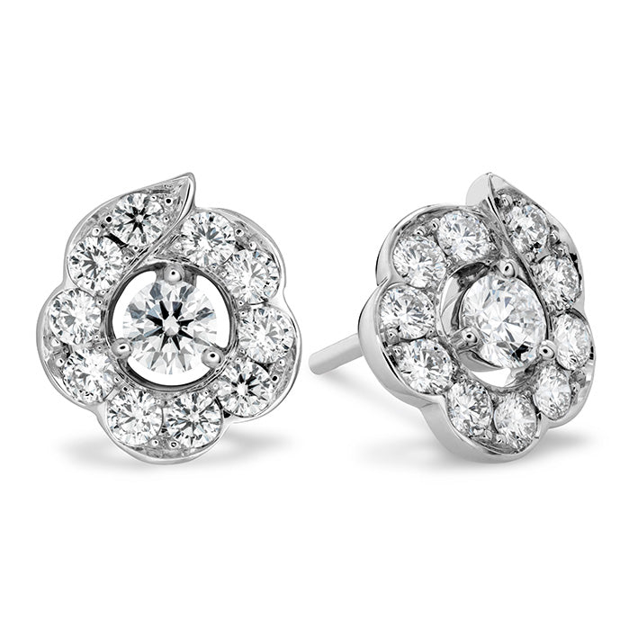 The Hearts On Fire Lorelei Bloom Stud Earrings by Hearts on Fire boast silver floral motifs adorned with circular diamond clusters. These earrings emphasize a prominent central stone encircled by smaller diamonds, offering elegance and sparkle for a stunning appearance.