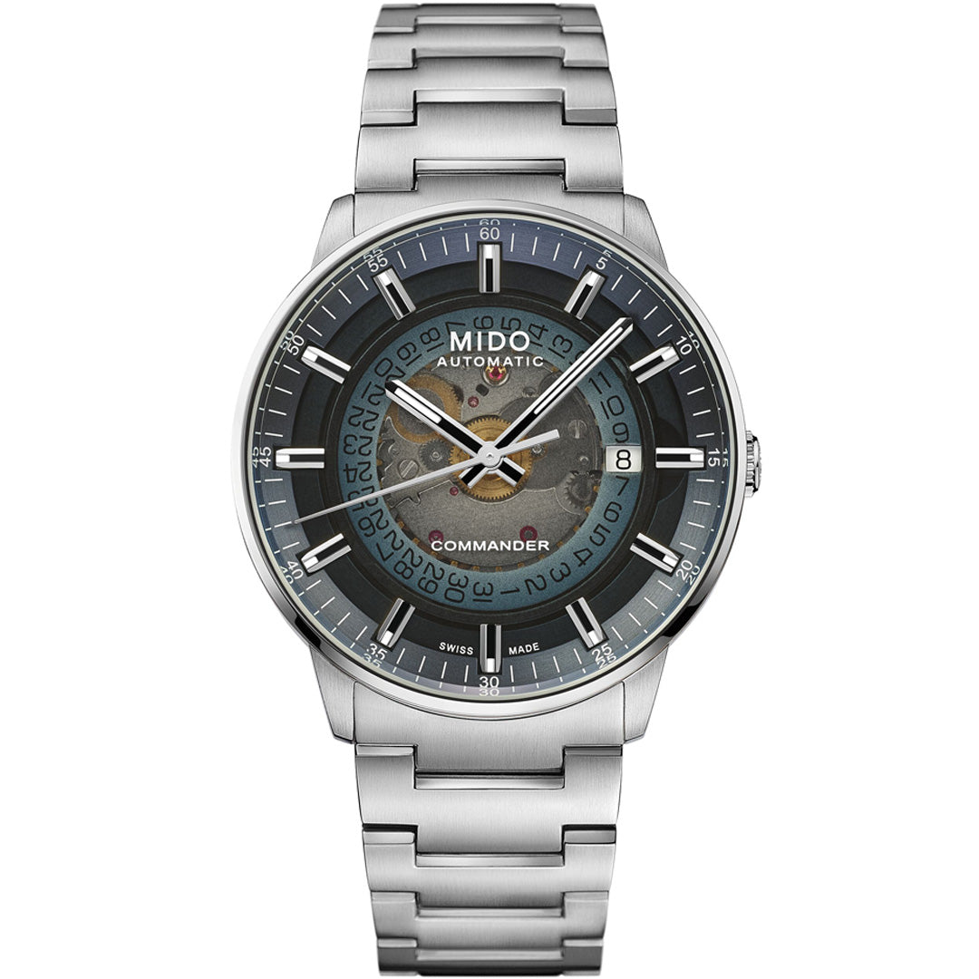 The MIDO Commander Gradient Automatic 40mm Watch features a stainless steel band, black and blue transparent acrylic dial revealing gears, Caliber 80 movement, silver hour markers, date display, and "Automatic" plus "Commander" on the dial.