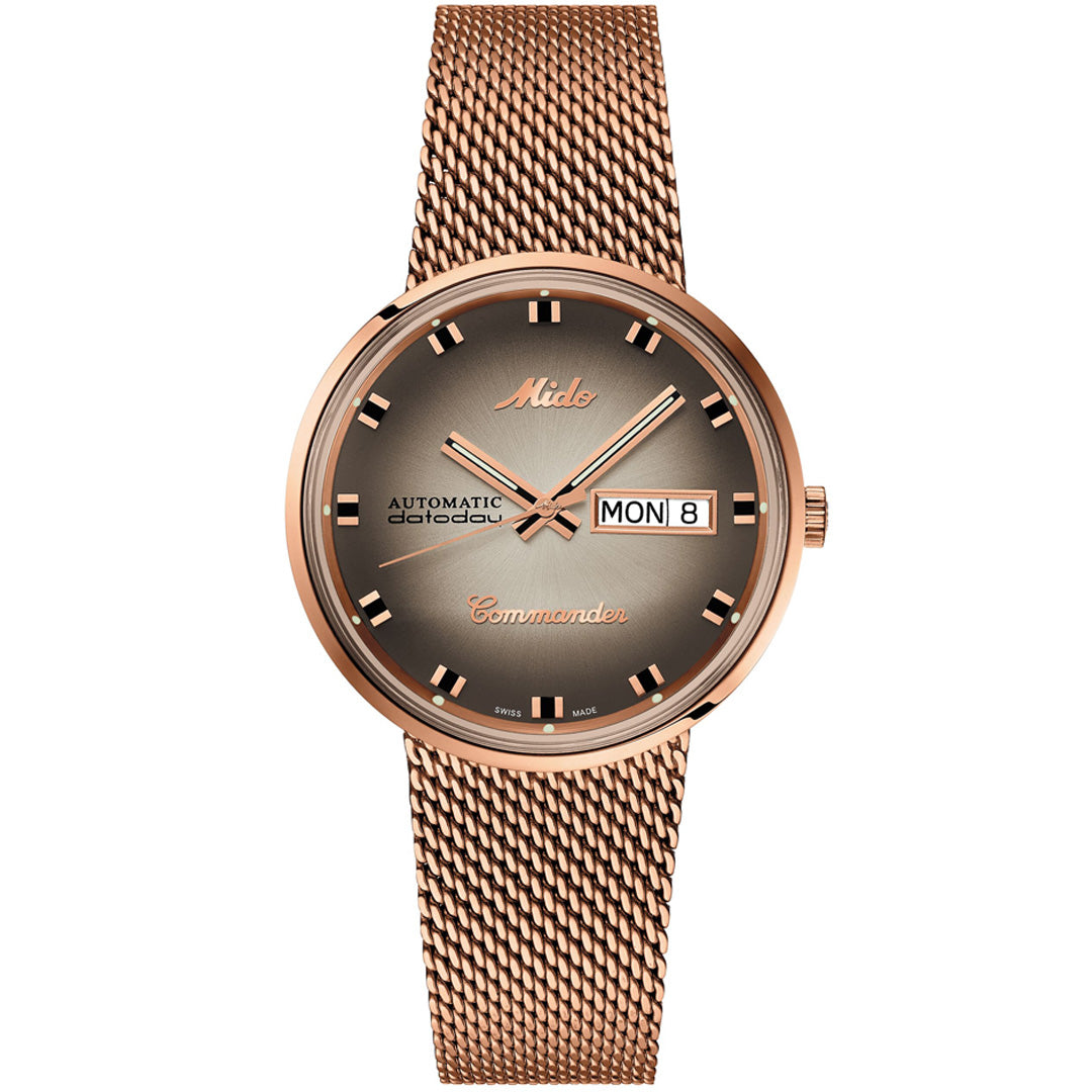The MIDO Commander Shade Automatic 37mm Watch features a rose gold case, mesh band, brown gradient dial with day-date at 3 o’clock, gold hands and indices—blending retro style with dependable automatic movement.