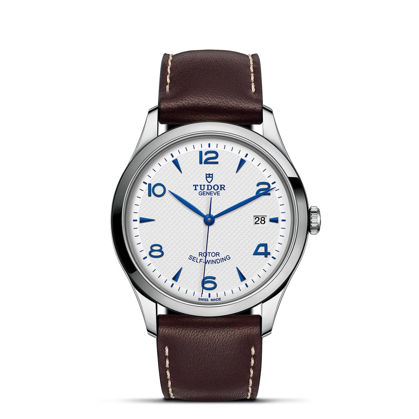 The TUDOR 1926 watch by TUDOR offers a white dial with blue Arabic numerals and a date display at the 3 o'clock position. It includes a silver case and is complemented by a brown leather strap with white stitching. The watch features "Rotor Self-Winding," embodying the spirit of mechanical timepieces inspired by Hans Wilsdorf.