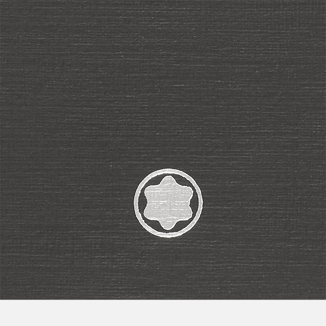 A dark textured surface highlights a small, white star-shaped logo with a border, embodying the sophistication of Montblanc's 2 Fine Stationery Notebooks #146 Slim, Black For Augmented Paper.