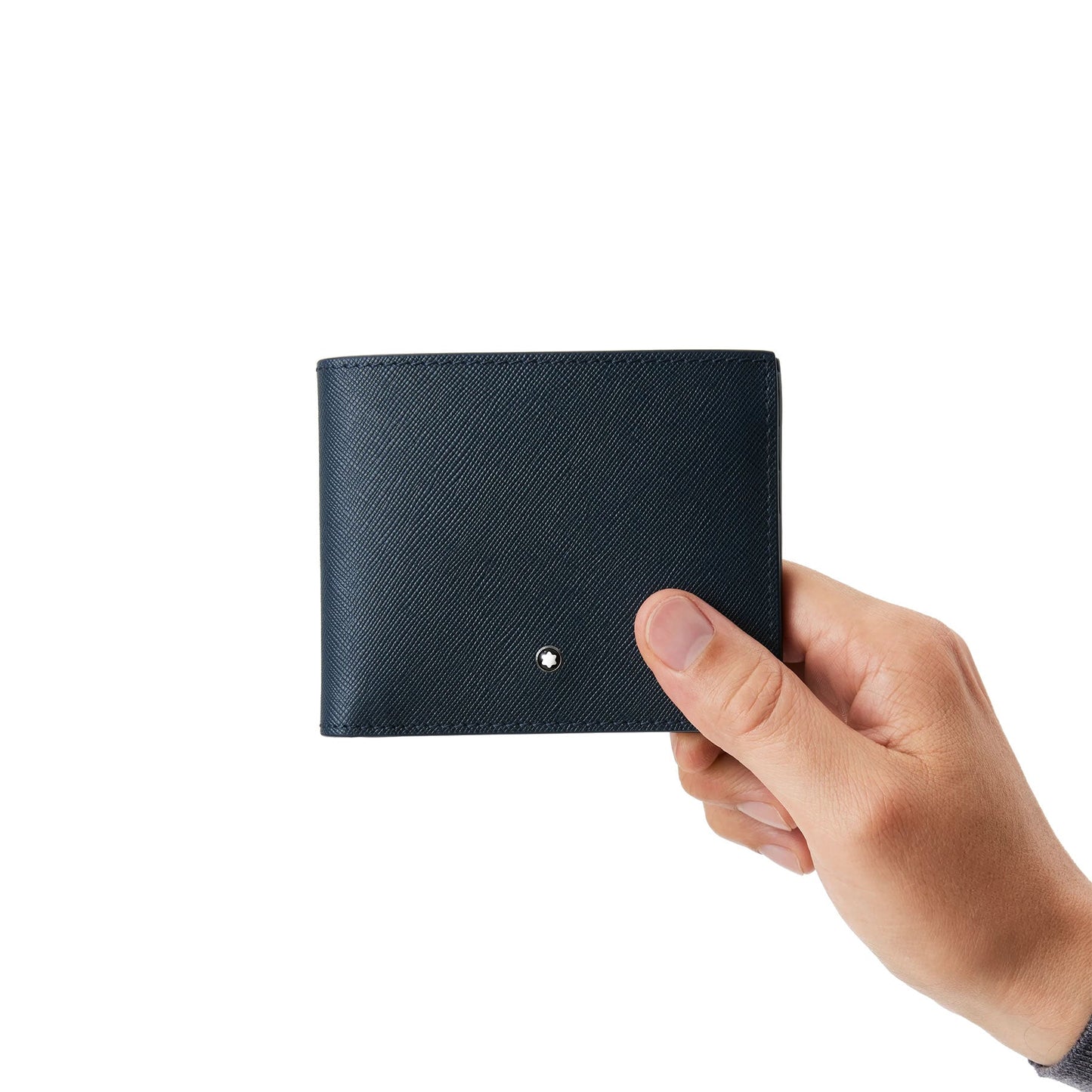 A hand holds an elegant, dark-colored Montblanc Sartorial Leather Wallet 6cc against a white background. The wallet, from the Montblanc brand, features a small metal emblem on its surface.