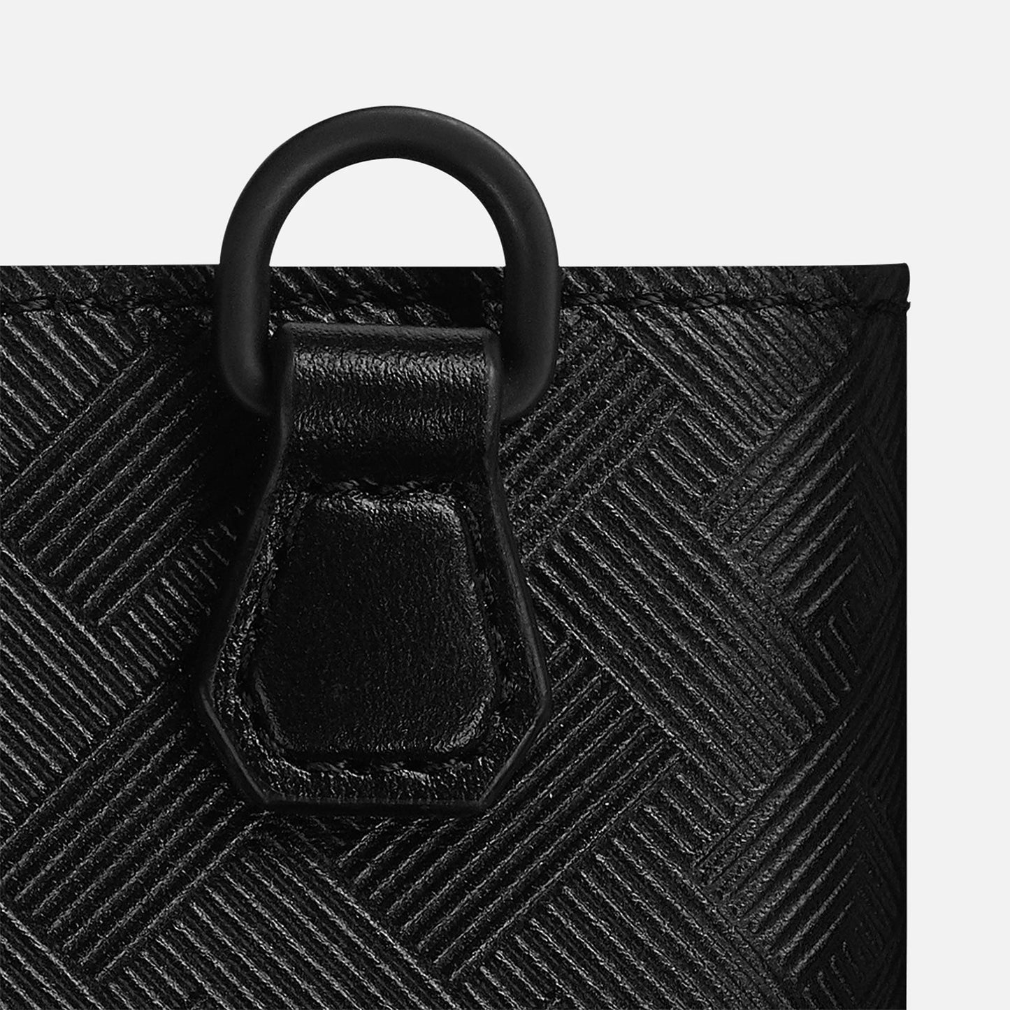 Close-up of a textured black leather strap featuring a circular black metal ring. The leather boasts a diagonal woven pattern, offering a striking contrast to the smooth texture of the strap loop. This sophisticated piece complements your Montblanc collection and is compatible with the Extreme 3.0 Compact Leather Wallet 6cc styles.