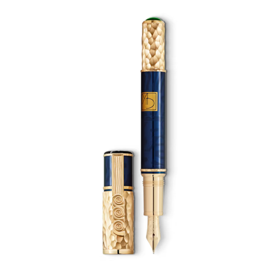 Introducing the Montblanc Masters Of Art Homage To Gustav Klimt Limited Edition Fountain Pen, an exquisite creation by Montblanc. This ornate fountain pen features a gold, textured barrel and cap inspired by the Vienna Secession, with intricate swirling patterns. The deep blue body is adorned with a gold emblem reminiscent of Gustav Klimt's artistry. Its elegant writing experience is heightened by a finely crafted gold nib.