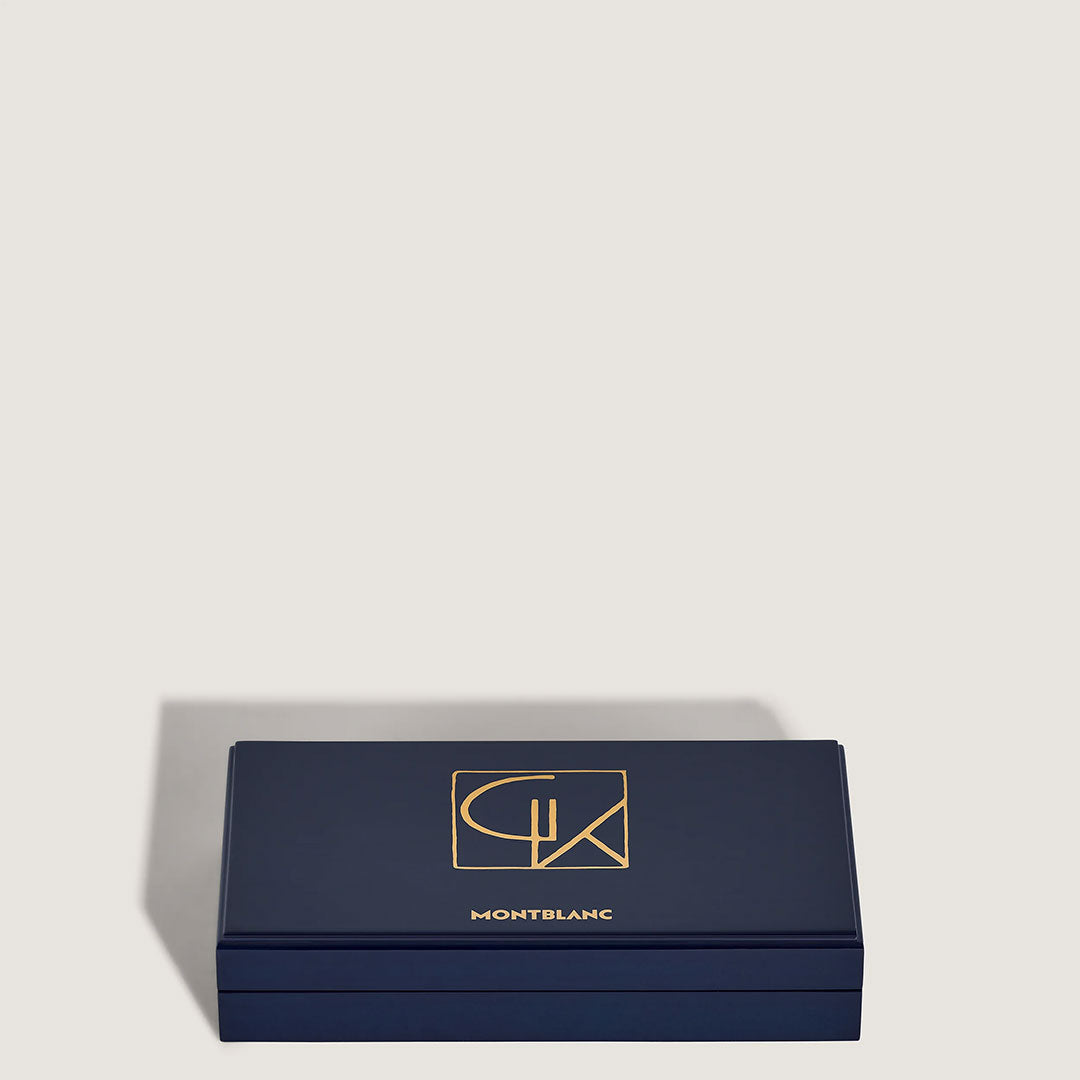 A rectangular navy blue Montblanc box with gold logo and lettering on the lid, from the Montblanc Masters of Art Homage to Gustav Klimt Limited Edition 4810 Rollerball Pen, displayed against a plain light background.