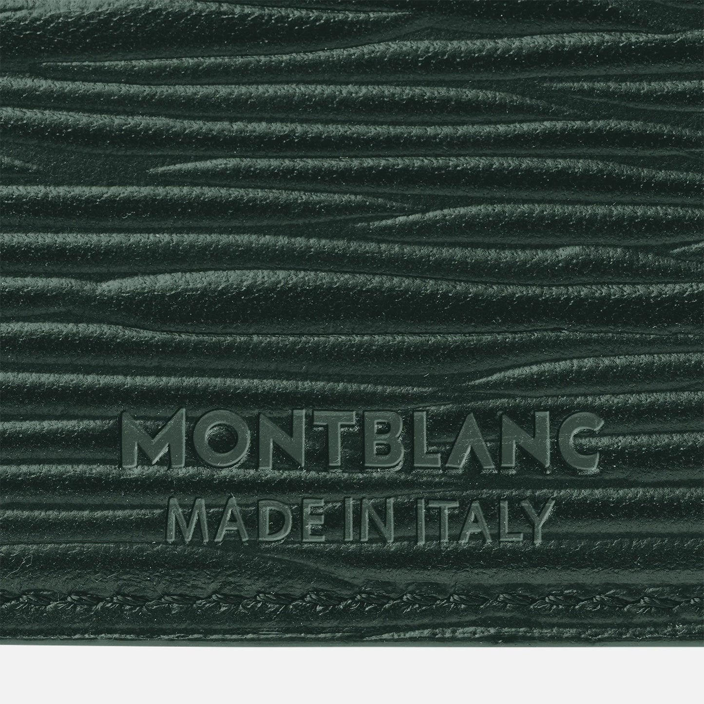 Close-up of the British green, premium leather featuring an embossed texture, with "MONTBLANC MADE IN ITALY" imprinted on the surface, evocative of a Montblanc Meisterstuck 4810 5cc card holder.