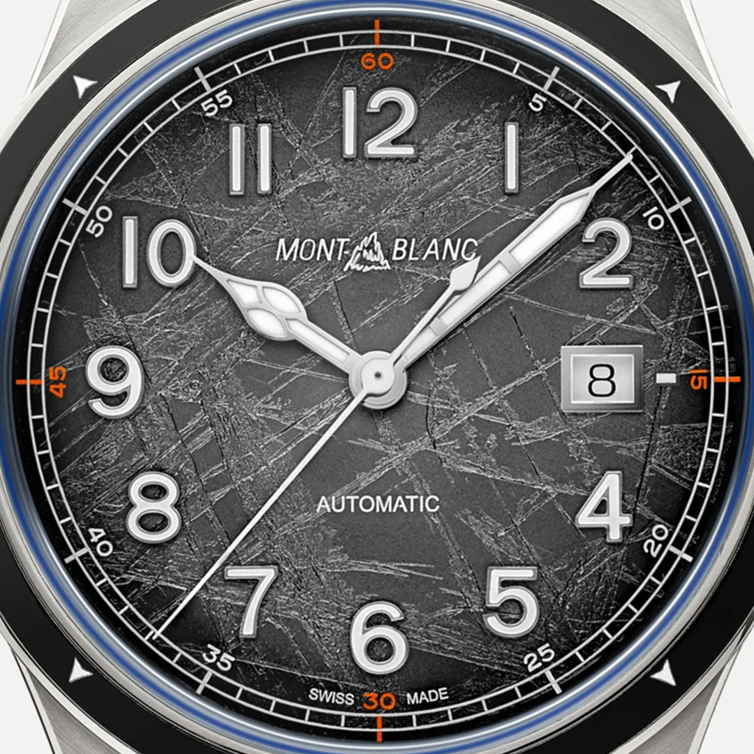 A close-up of the Montblanc 1858 Date 0 Oxygen The 8000 Automatic 41mm Watch highlights its textured black dial, where silver hour and minute hands sweep gracefully, complemented by a date display at the 3 o'clock position. Capturing the essence of exploration, this timepiece features Arabic numerals with striking orange accents at the 15, 30, 45, and 60-second marks. Powered by the automatic caliber MB 24.17, it ensures precision throughout your adventures.
