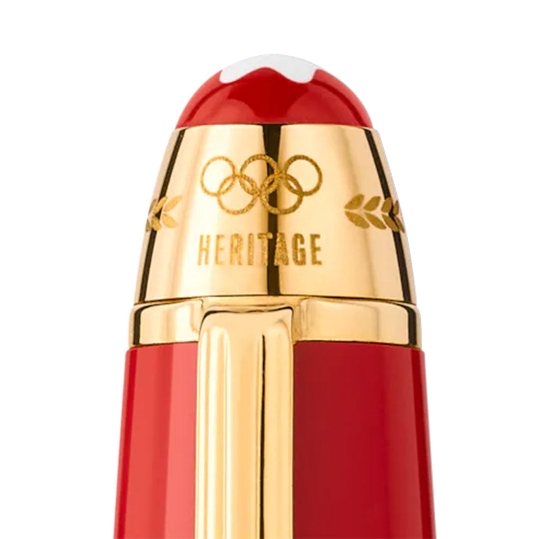 A close-up of the Montblanc Meisterstück x Olympic Heritage Paris 1924 LeGrand Rollerball showcases its polished cap adorned with a gold emblem reminiscent of Olympic rings. This detail evokes the spirit of the 1924 Paris Olympic Games, accompanied by an engraving of the word "HERITAGE" next to a laurel design.