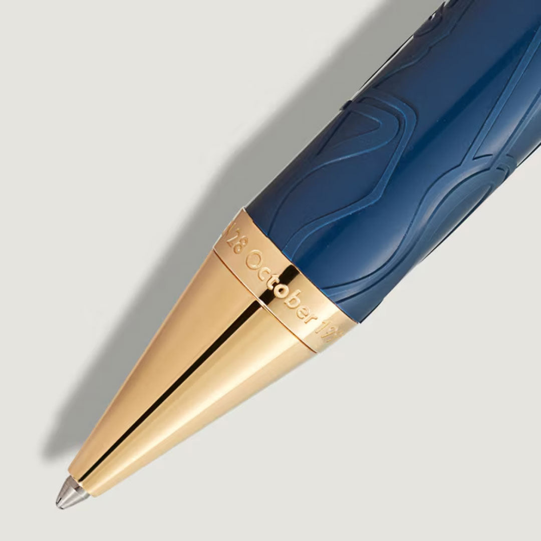 A close-up of a Montblanc Pen Great Characters Homage to Queen Special Edition Ballpoint Pen, showing its gold tip and engraved “28 October 1922” on the gold section near the point.