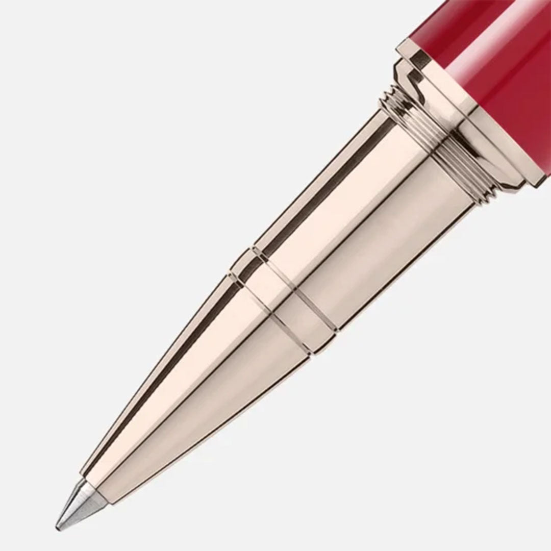 A close-up showcases the sleek metal tip of the Montblanc Muses Marilyn Monroe Special Edition Rollerball Pen, featuring a glossy red barrel reminiscent of Marilyn Monroe's iconic lipstick. This pen from Montblanc boasts a shiny metallic finish and pointed nib, all set against a plain light gray background.