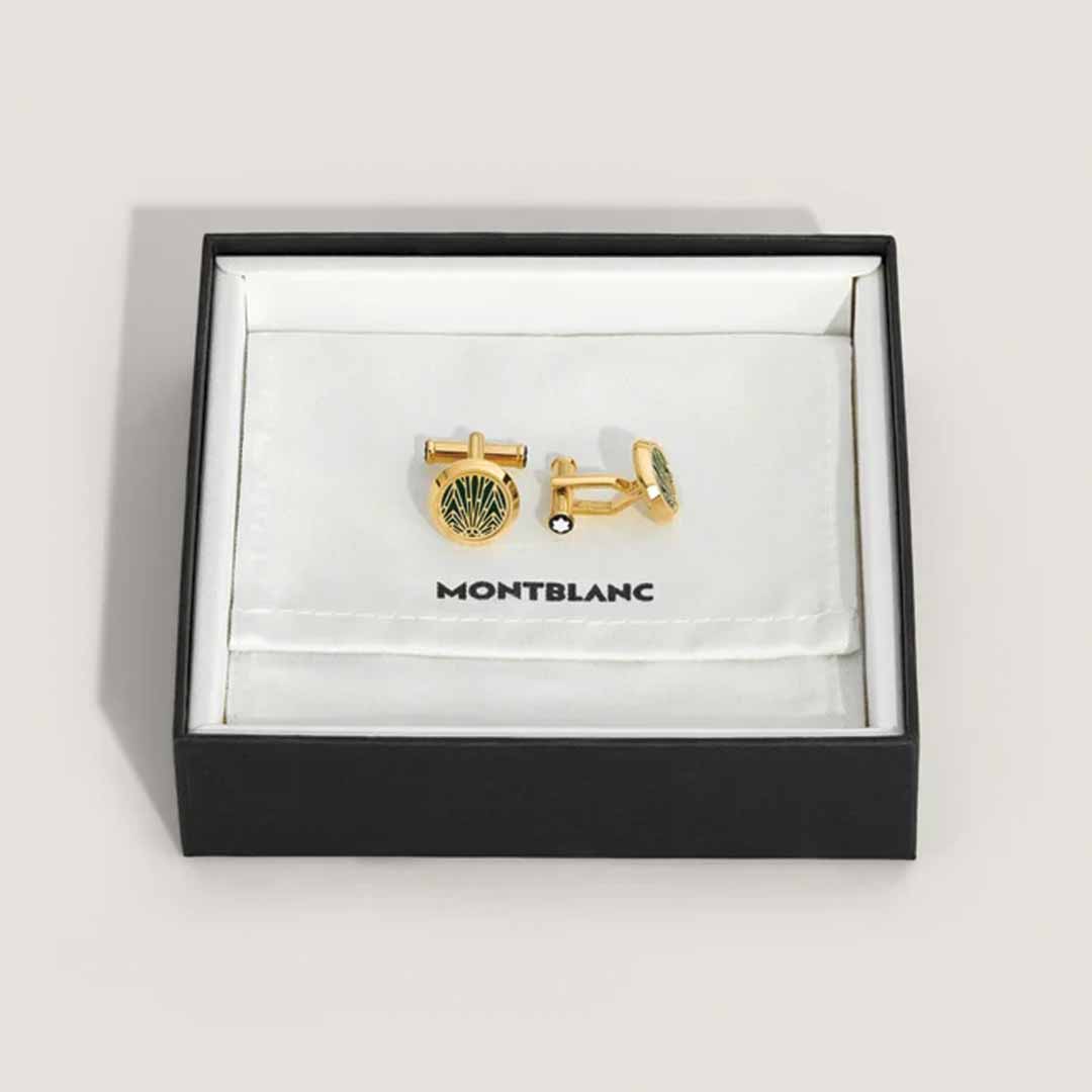 The Montblanc Meisterstuck The Origin Collection Green Cufflinks, featuring a sunburst design with a green lacquer inlay, are elegantly displayed in an open Montblanc box on a white background.