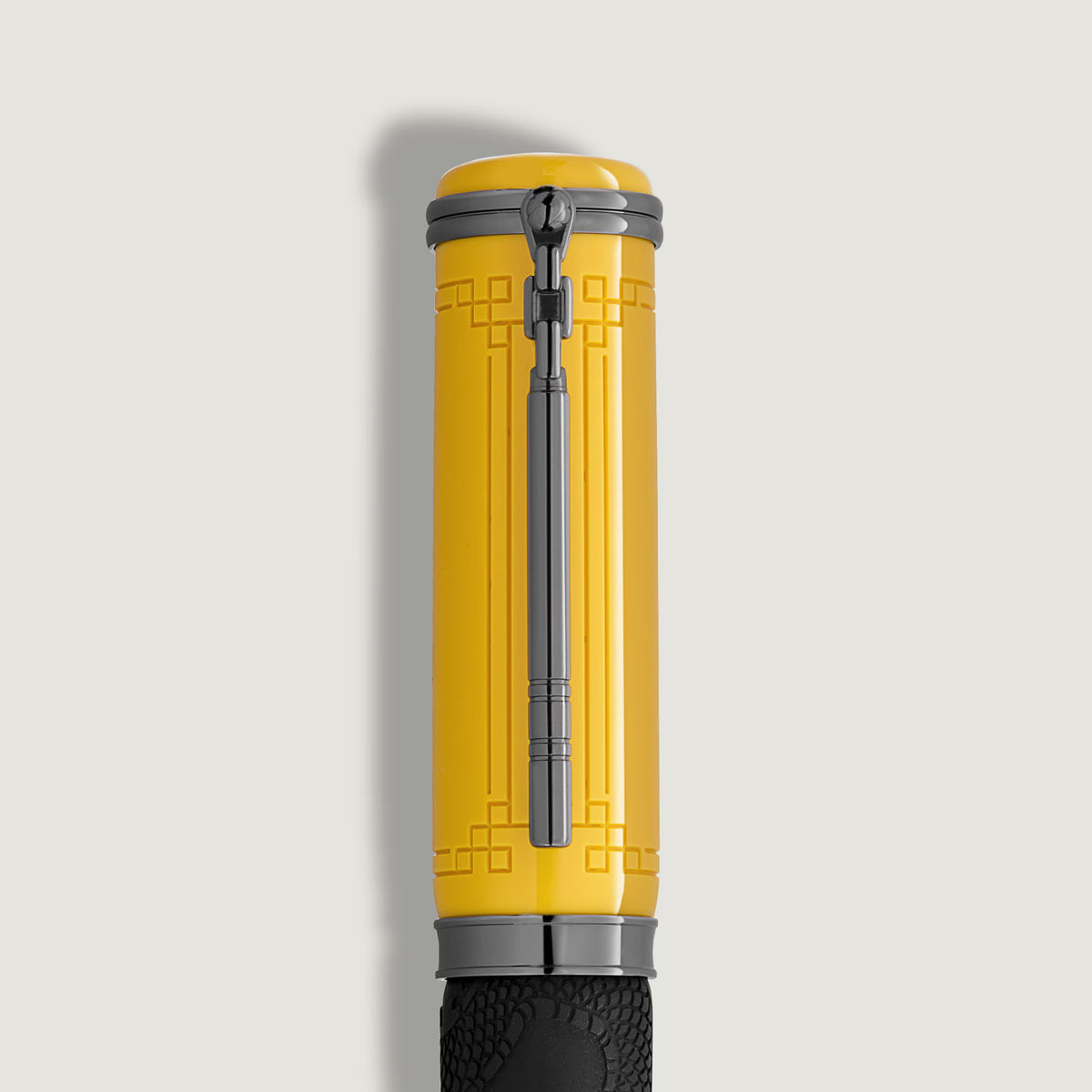 Yellow Montblanc Great Characters Bruce Lee Special Edition Rollerball Pen cap featuring a black clip and embossed geometric patterns.