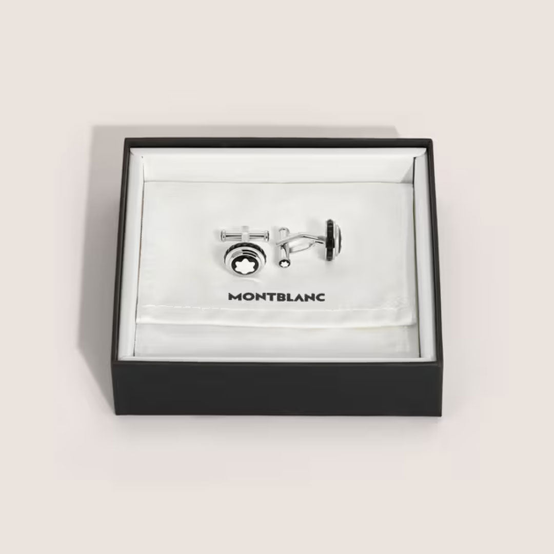 A pair of Montblanc Great Characters Homage to Queen cufflinks in silver steel with a black and white emblem, presented in an open black and white Montblanc box lined with white cloth.