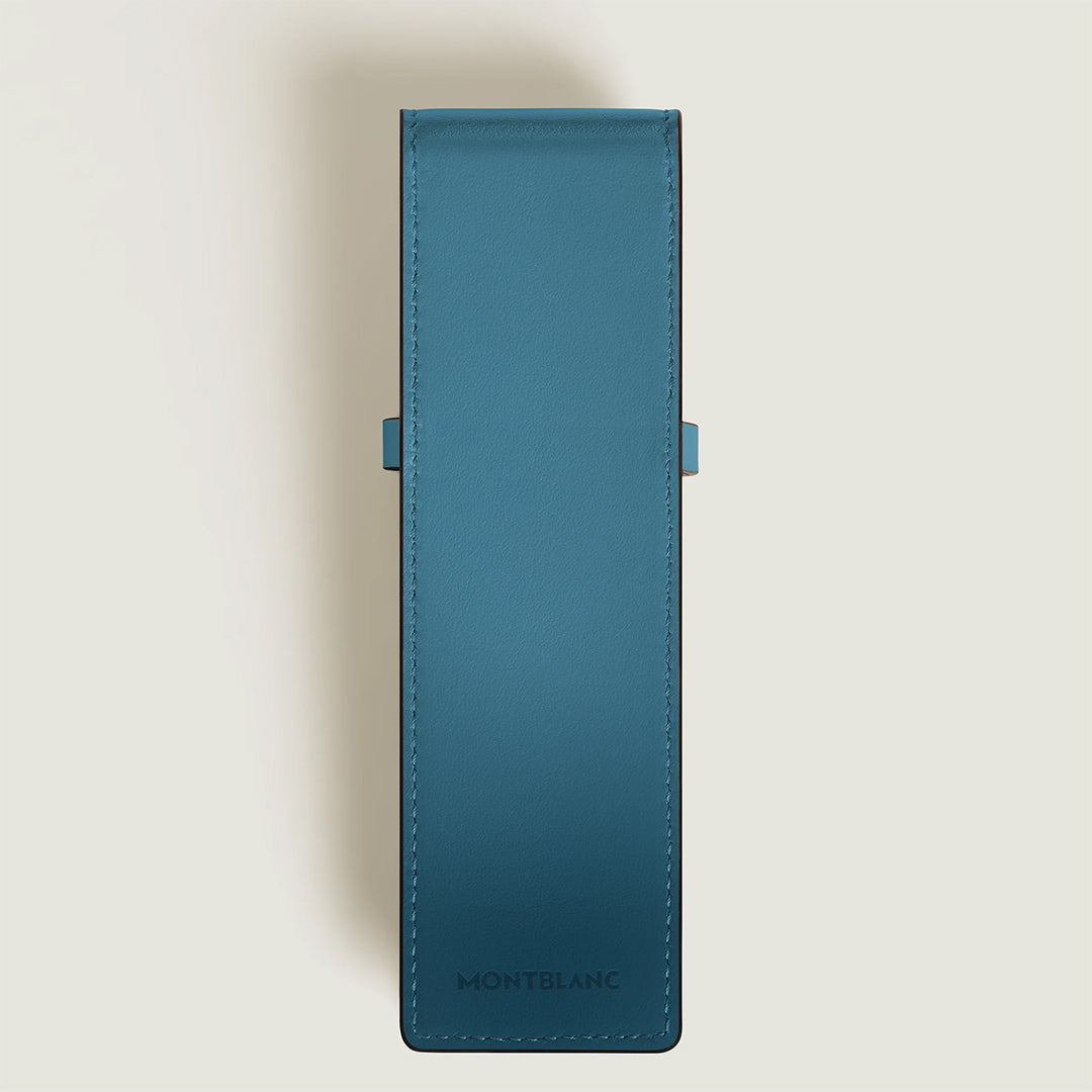 The Montblanc Meisterstück Leather Double Pen Pouch, in smoky blue sfumato-effect leather with visible stitching, is shown closed from above against a light beige background. It holds either a Meisterstück Classique or LeGrand pen.