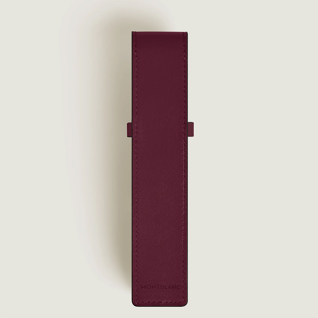 The Montblanc Meisterstück 1-Pen Pouch, crafted in burgundy leather with a rectangular shape and flap cover, elegantly features an embossed "MONTBLANC" at the bottom. It exudes sophistication against a light gray background.