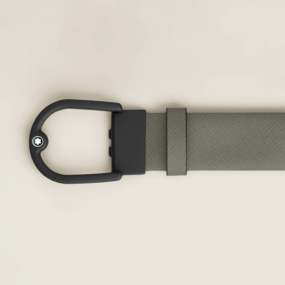 A close-up of the Montblanc Horseshoe Buckle 35MM Grey Leather Belt, showcasing its Saffiano pattern and matte black buckle with a white star emblem, displayed on a light beige background.