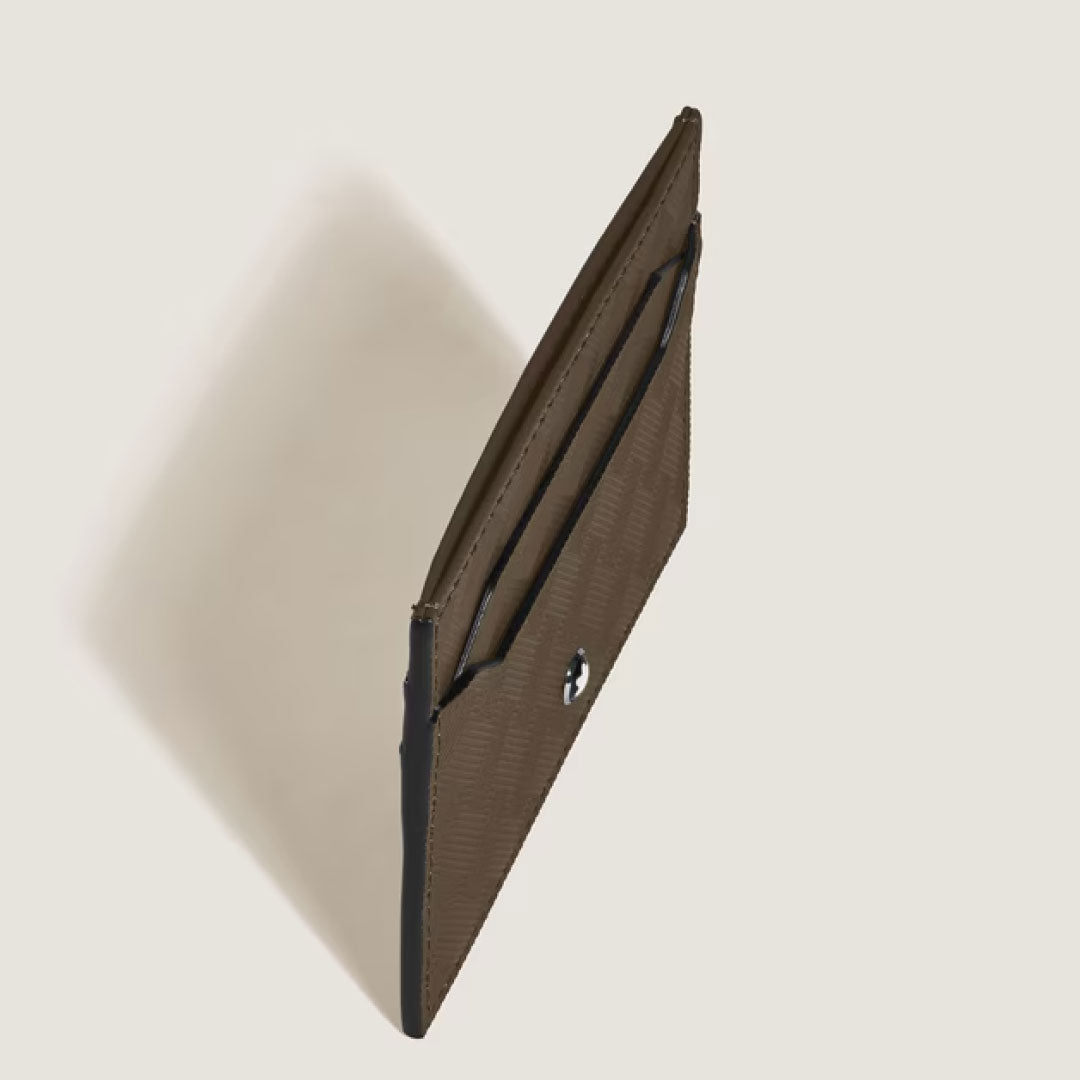 The Montblanc Extreme 3.0 5cc Leather Card Holder by Montblanc, in slim noisette leather with a snap button closure and open side pocket, is shown upright against a light beige background.