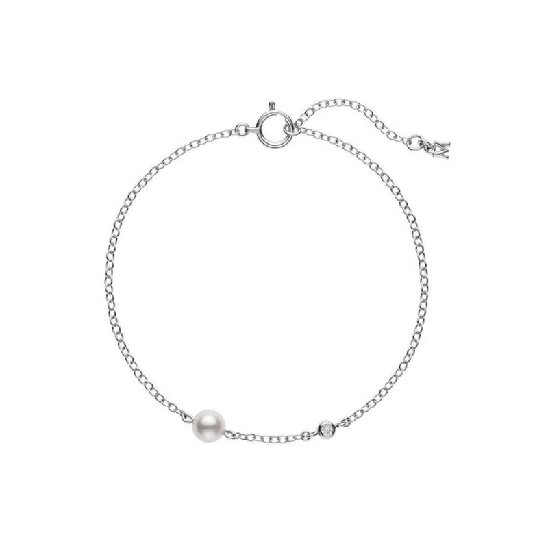 The Mikimoto 18K White Gold Diamond and Akoya Cultured Pearl Station Bracelet is a simple and elegant piece, featuring a delicate 18K white gold chain adorned with an Akoya cultured pearl and a small round gemstone. The bracelet includes an adjustable clasp with a charming end detail.