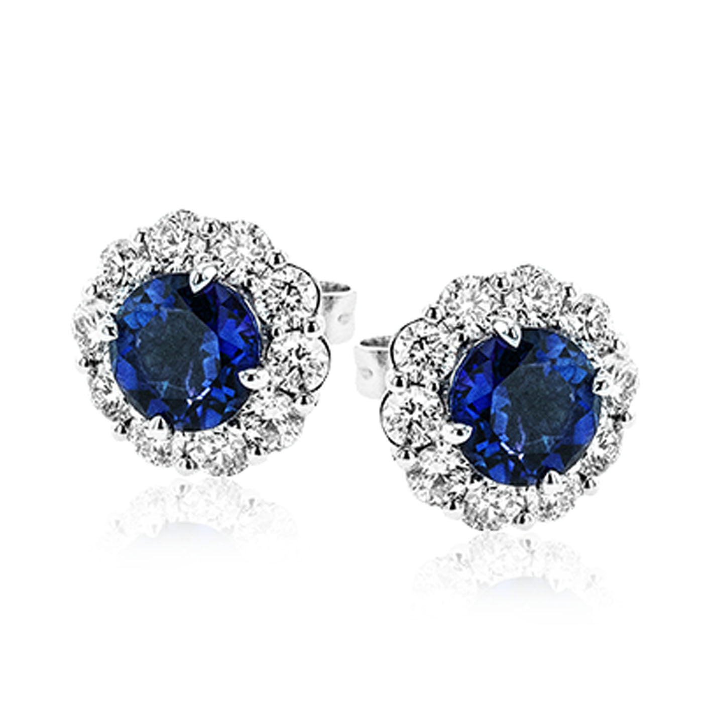 The Simon G. 18K White Gold Sapphire with Diamond Stud Earrings by Simon G features elegant stud earrings adorned with large round sapphires encircled by a halo of smaller sparkling diamonds, set in an 18 karat white gold setting.