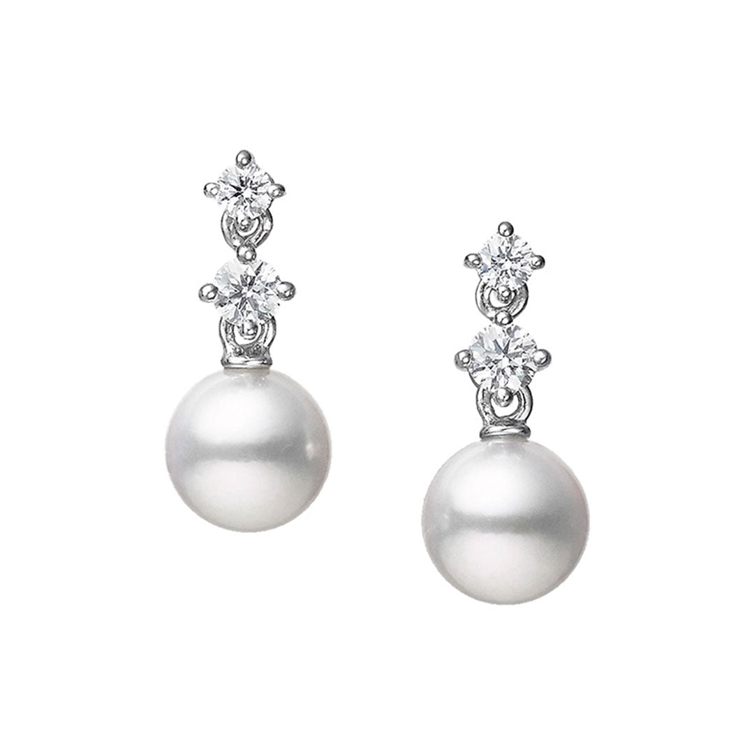 Elevate your look with the Mikimoto Morning Dew Drop Earrings. These earrings from Mikimoto showcase a stunning Akoya cultured pearl at the base, accentuated by two small round diamonds elegantly stacked above, all set in radiant 18K white gold against a simple white background.