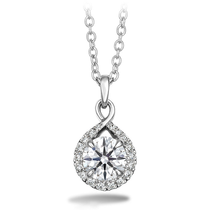 The Hearts On Fire Optima Necklace by Hearts on Fire showcases a white gold pendant adorned with a sizable round diamond at its center, encircled by smaller diamonds arranged in a teardrop shape. It is elegantly suspended on an interlinked loop chain.
