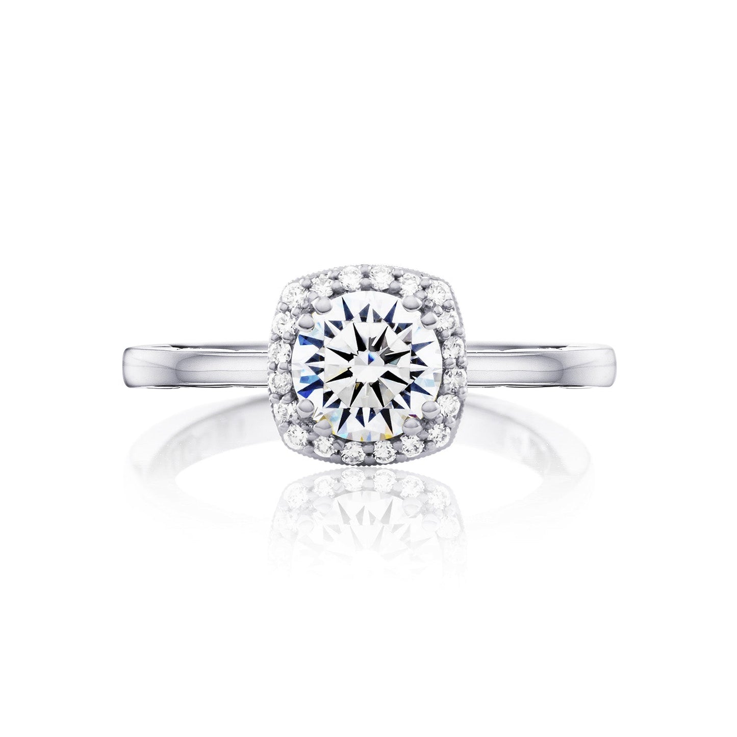 A close-up of the Tacori Coastal Crescent 14K White Gold Round Brilliant Semi Mount Engagement Ring, showcasing a large round diamond at its center surrounded by a halo of smaller diamonds. The ring features a sleek, polished band with diamond accents that beautifully reflect light, all set against a plain white background.