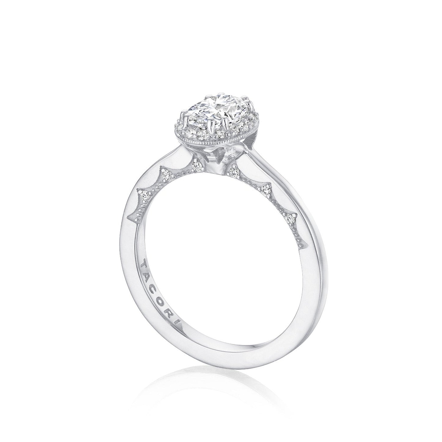 A Tacori Coastal Crescent 14K White Gold Oval Semi Mount Engagement Ring features a large oval diamond in the center, surrounded by a halo and smaller diamonds intricately detailed on the band, all embodying the elegant Coastal Crescent design. The "TACORI" engraving on the side signifies timeless sophistication in engagement rings.