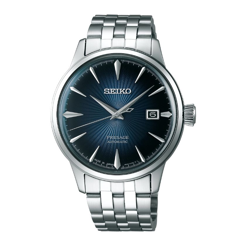 A Seiko Presage Cocktail Time automatic wristwatch with manual winding, featuring a 40.5mm size and stainless steel bracelet. The deep blue sunburst dial is enhanced by sapphire crystal, showcasing silver hour markers, a date window at 3 o'clock, and the iconic Seiko logo positioned below the 12 o'clock marker.