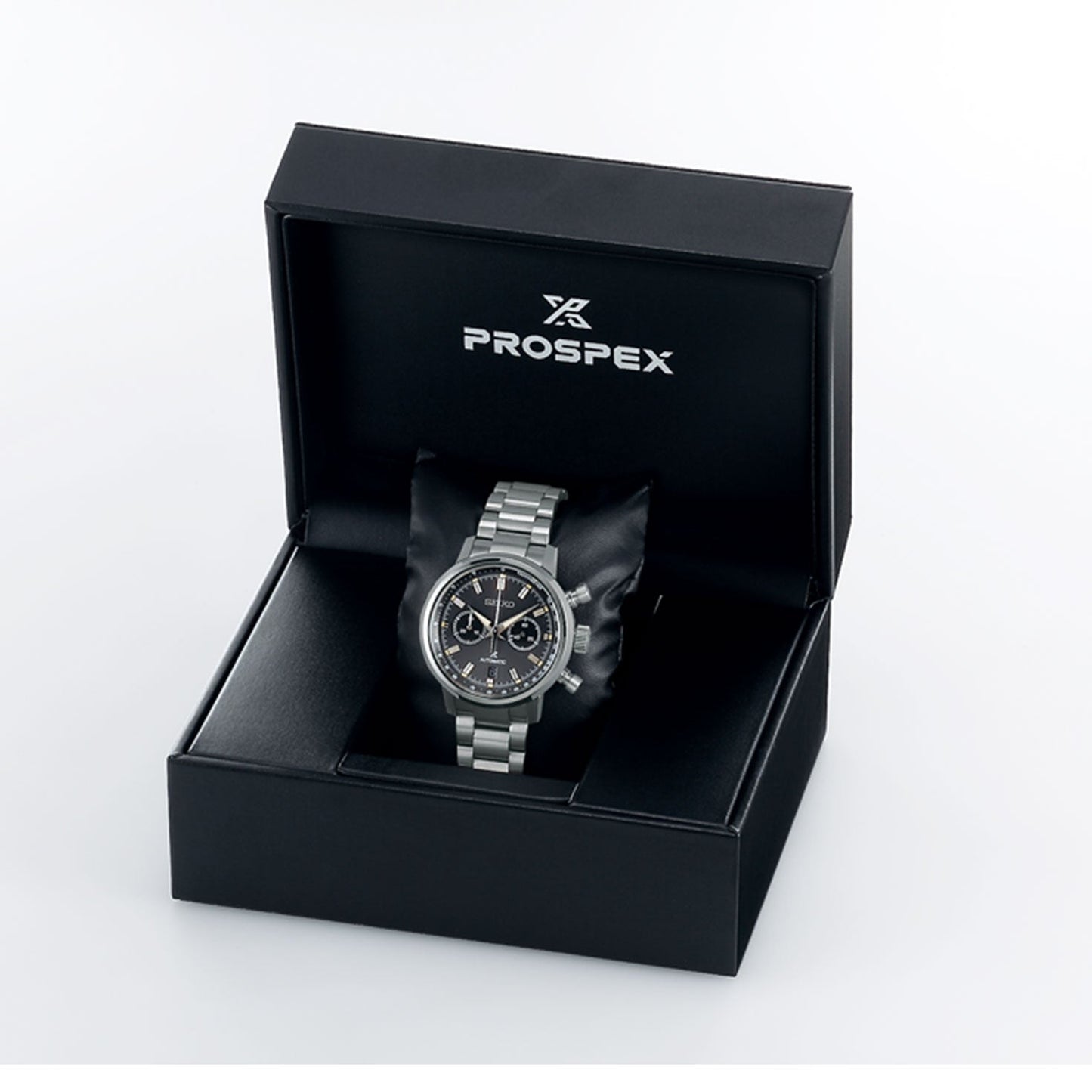 The limited edition Seiko Prospex Speedtimer Automatic With Manual Winding 42.5mm Watch is elegantly showcased in an open black box, featuring the "PROSPEX" logo on the inside of the lid. This silver chronograph watch features a sleek black dial set against a pristine white background.