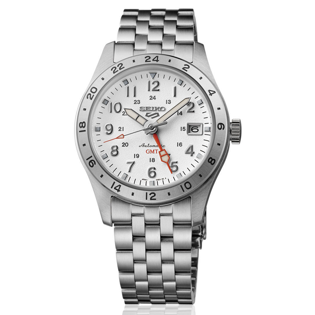 The Seiko 5 Sports Field Series Automatic 39.4mm features a stainless steel case, silver dial with black markers, date at 3 o’clock, red GMT hand, 24-hour bezel, and a metal link bracelet.