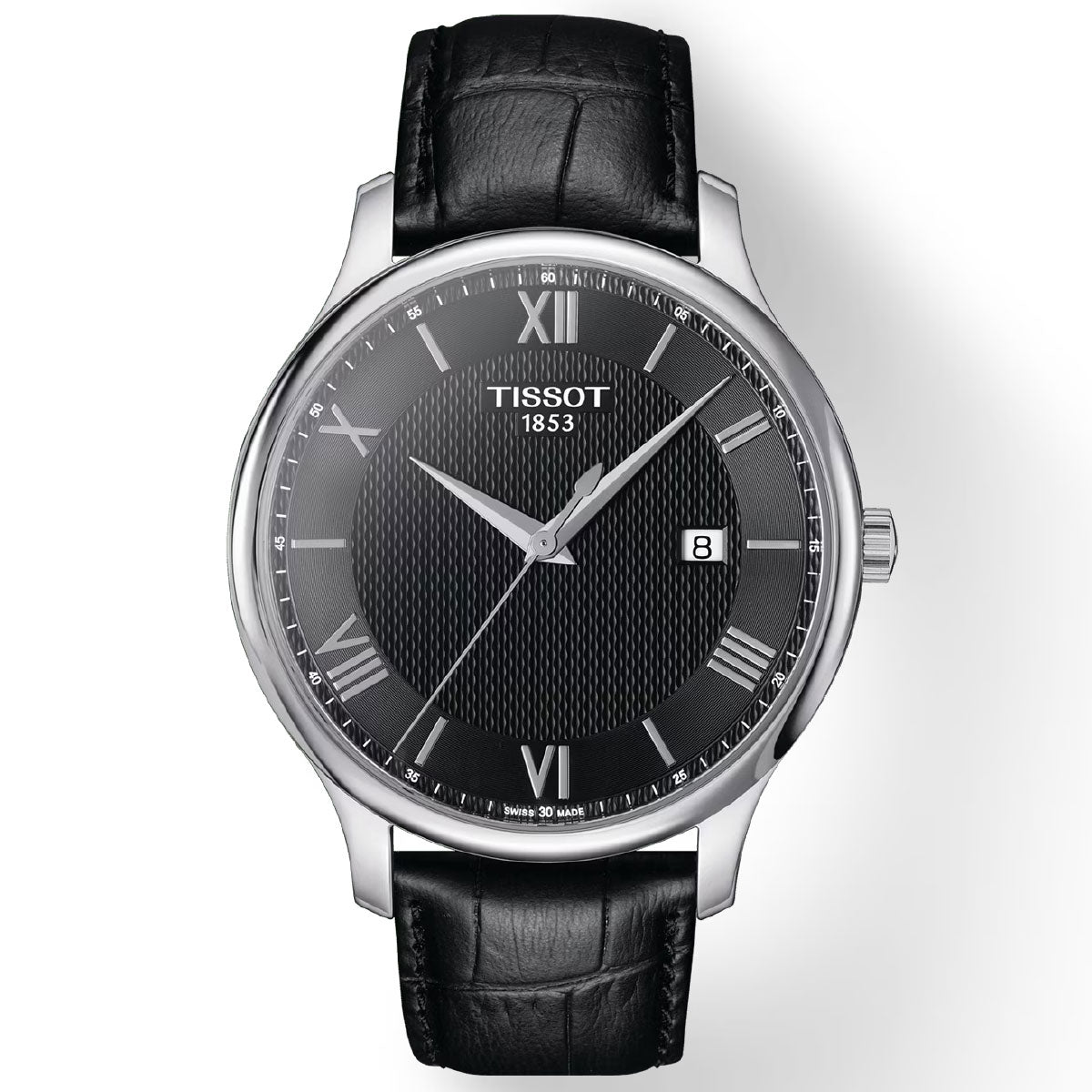 The Tissot Tradition Quartz 42mm Watch boasts a black textured dial adorned with silver Roman numerals and a date window at the 3 o'clock position. Featuring Swiss Quartz Movement, it comes with a silver bezel and a black leather strap. The dial is embellished with the Tissot brand name and "1853," enhancing its vintage-inspired design charm.