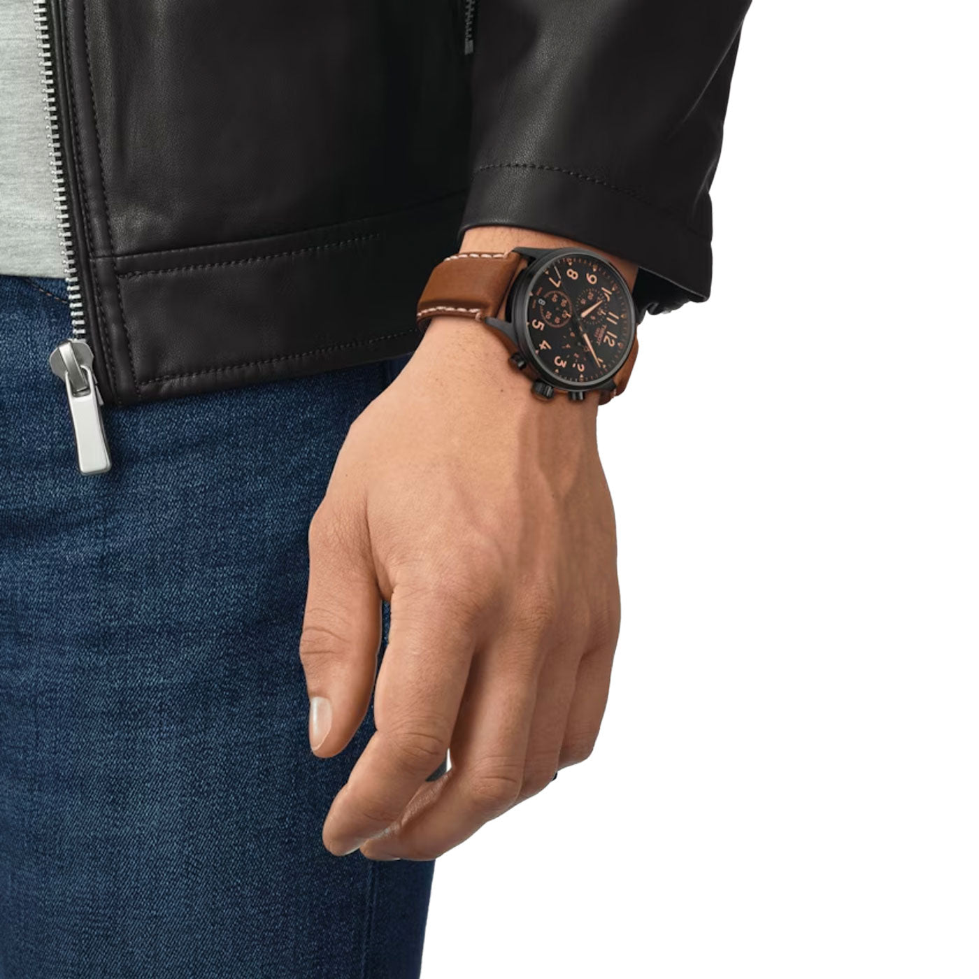A person is wearing a black leather jacket and blue jeans, complemented by a Tissot Chrono XL Quartz 45mm Watch featuring a 316L stainless steel case. The hand is relaxed by their side, exuding effortless style.