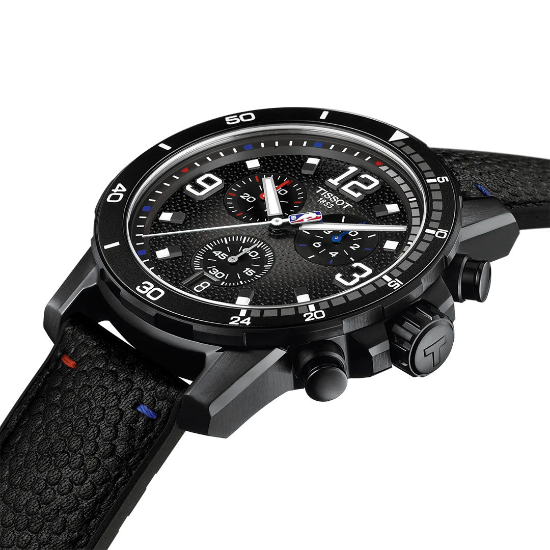 The Tissot Supersport NBA Special Edition Quartz 45.5mm Watch features a black textured dial with white markings, three subdials, silver hands, black leather strap with red and blue stitching, and a "T" logo on the crown.