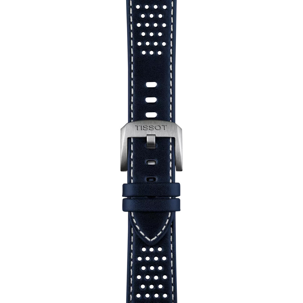 The navy blue strap for the Tissot PR516 Powermatic 80 Automatic 38mm Watch has white stitching, perforations for ventilation, a "Tissot"-engraved metal buckle, and multiple holes for adjustable sizing, beautifully complementing its stainless-steel case.