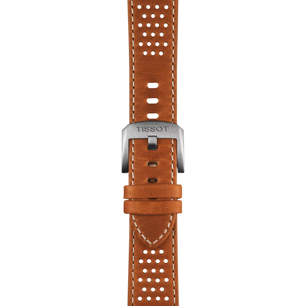 The Tissot PR516 Powermatic 80 Automatic 38mm Watch features a close-up of a brown leather strap with white stitching, perforated holes, and a loop to secure the end. The stainless-steel case and metallic buckle proudly display the "Tissot" brand name.