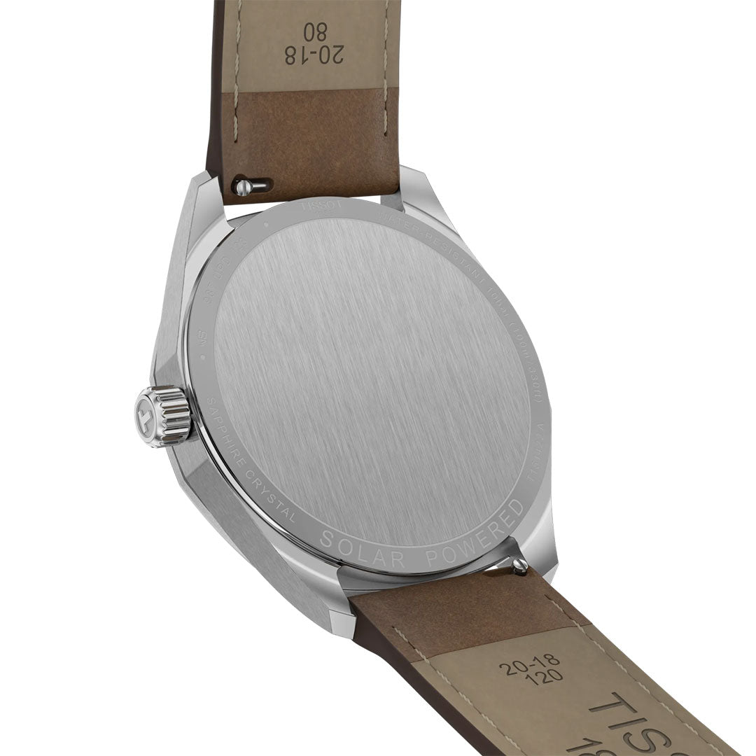 A close-up view of the back of a Tissot PRC 100 Solar Quartz 39mm Watch with a brown leather strap. The brushed stainless steel case is engraved with "SOLAR POWERED," showcasing Tissot’s advanced solar-powered technology.