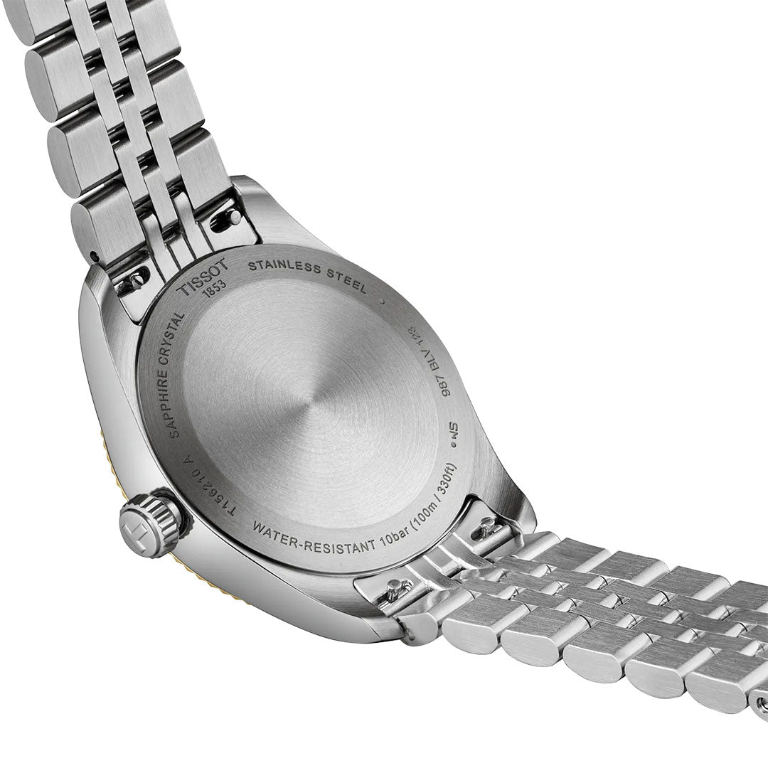 Close-up of the back of a Tissot Ballade Quartz 34mm Watch, highlighting engraved details such as water resistance, sapphire crystal, model numbers, and its interchangeable stainless steel bracelet.