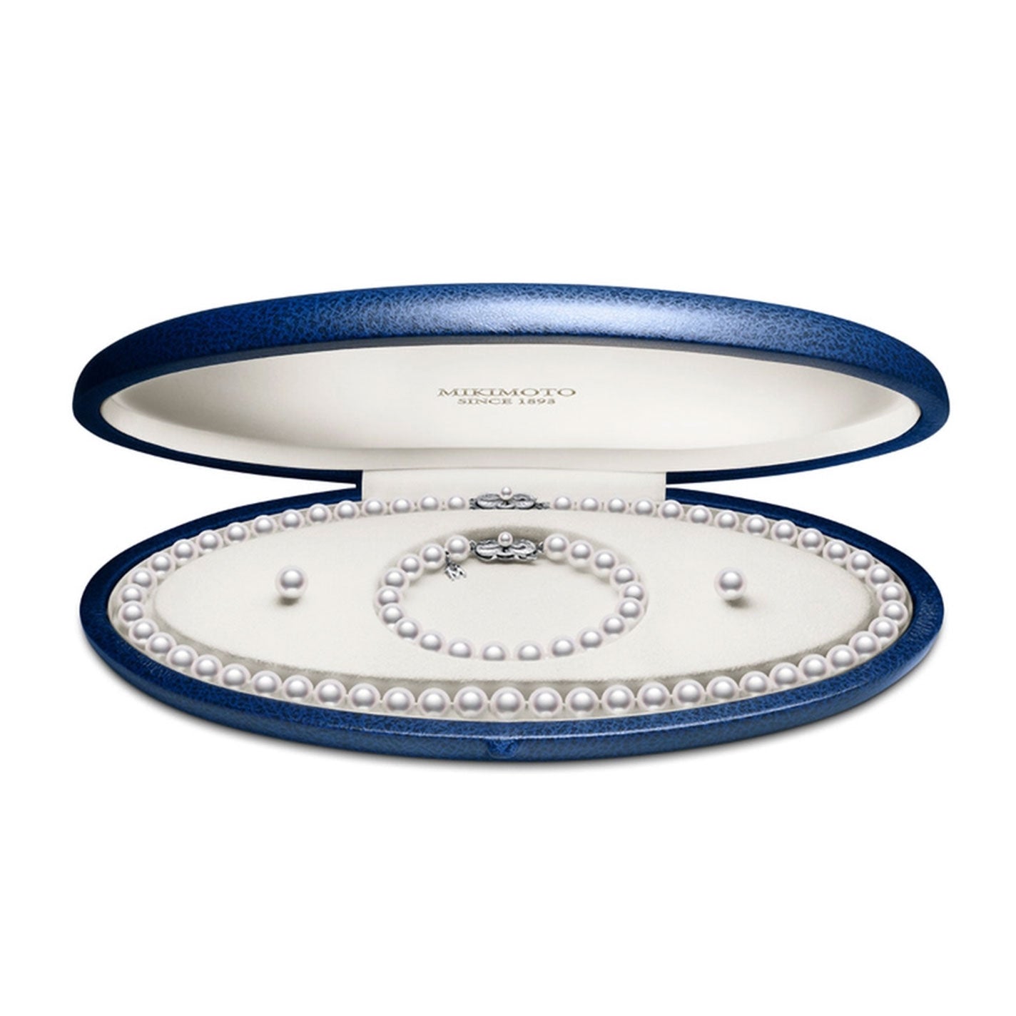 A luxurious blue velvet oval jewelry box contains the exquisite Mikimoto 18K White Gold Akoya Cultured Pearl Strand Necklace and Bracelet with Stud Earrings Three-Piece Set. The cream-colored interior of the box provides a striking contrast to the evenly spaced pearls, each adorned with delicate Mikimoto clasps.