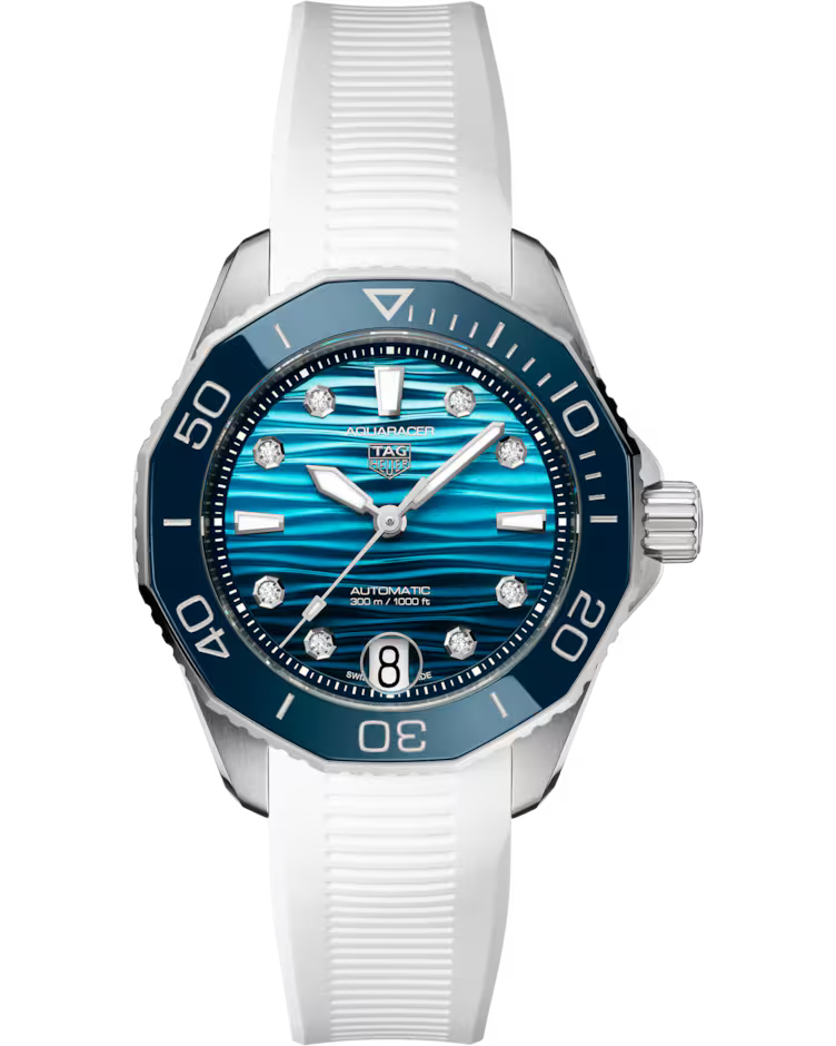 The TAG Heuer Aquaracer Professional 300 Date Automatic 36mm Watch by TAG Heuer features a blue wave-patterned dial with diamond hour markers, a white strap, and a blue bezel with minute markings. The date window is positioned at the 6 o’clock mark.