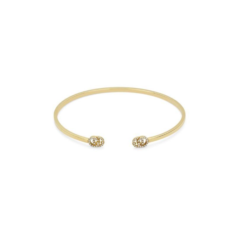 The exquisite Gucci Running G 18K Yellow Gold Diamond Cuff Bracelet, from GUCCI Fine Jewellery, showcases a sleek open bangle design with ball-shaped ends adorned with small diamonds. The elegant piece is beautifully displayed against a plain white background.