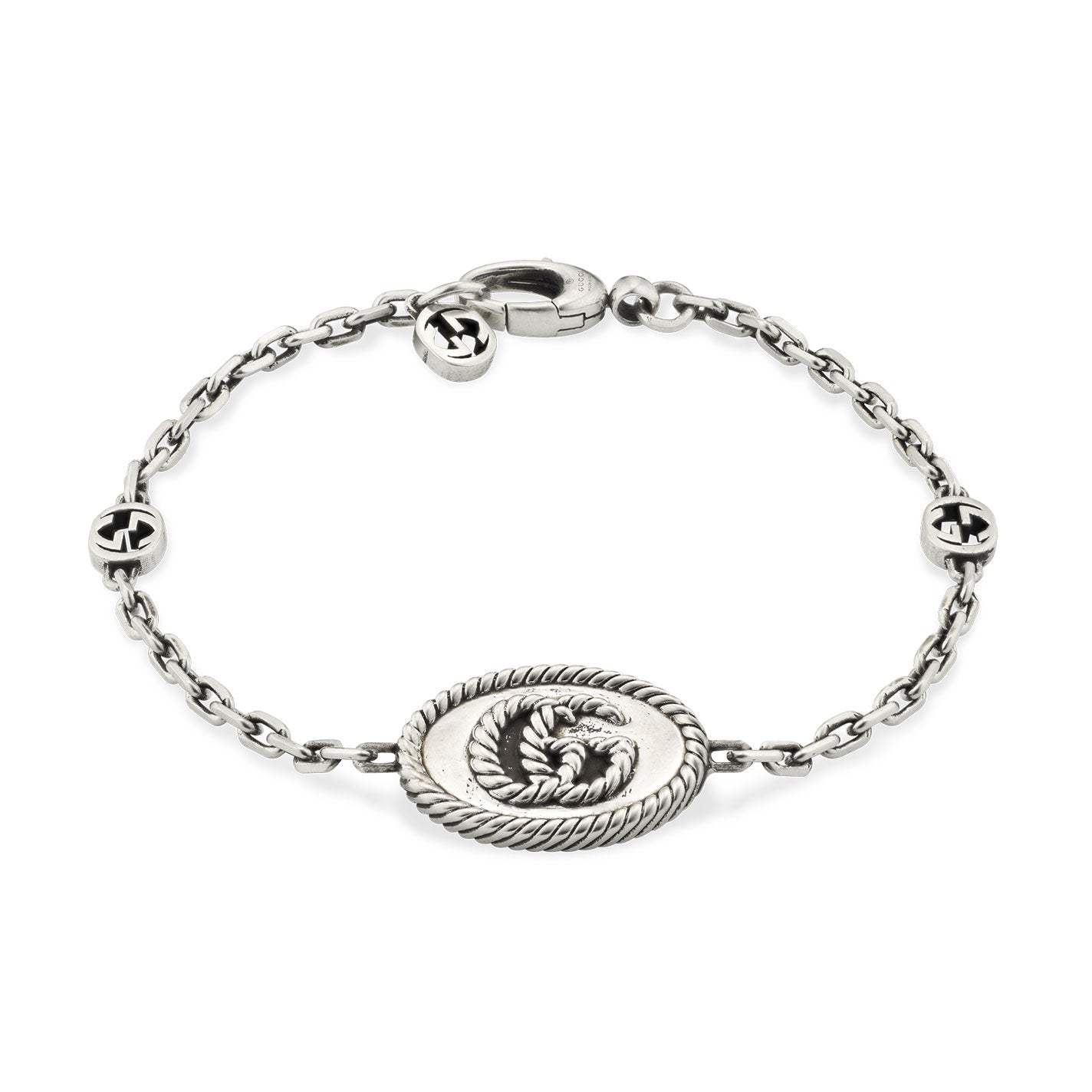 A Gucci sterling silver chain bracelet from GUCCI Fine Jewellery, featuring an interlocking G pendant in the center and accented by two round motifs with the iconic Double G design. It is secured with a simple lobster claw clasp.