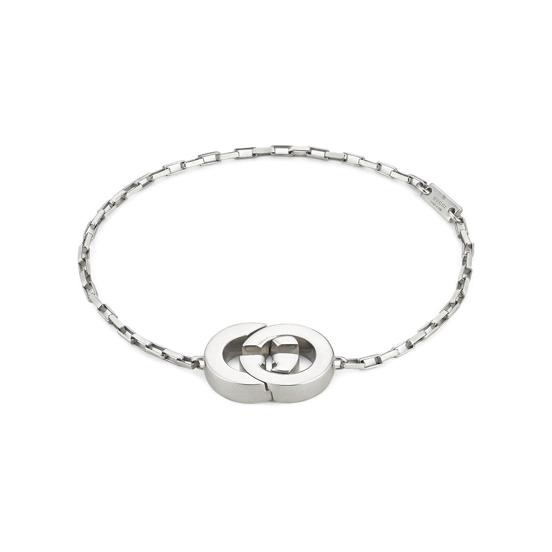 The Gucci Interlocking G Charm Sterling Silver Bracelet by GUCCI Fine Jewellery features interlocking G charms on a sleek rectangular-link chain, offering a modern, minimalist look inspired by classic designs.