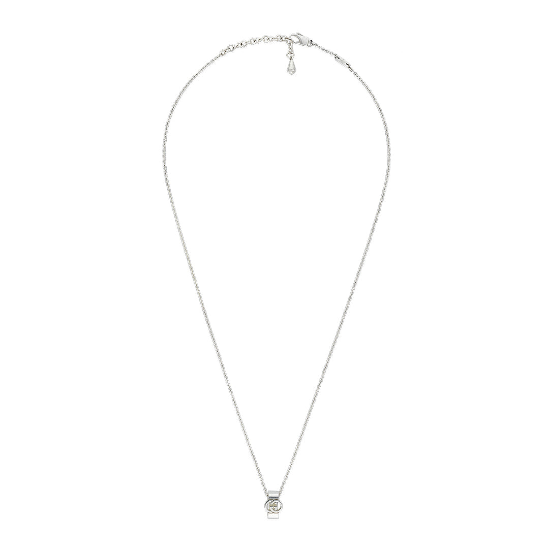 The Gucci Interlocking Sterling Silver Necklace Pendant by GUCCI Fine Jewellery features a thin chain and small circular Interlocking G pendant with a clear gemstone, shown on a white background.