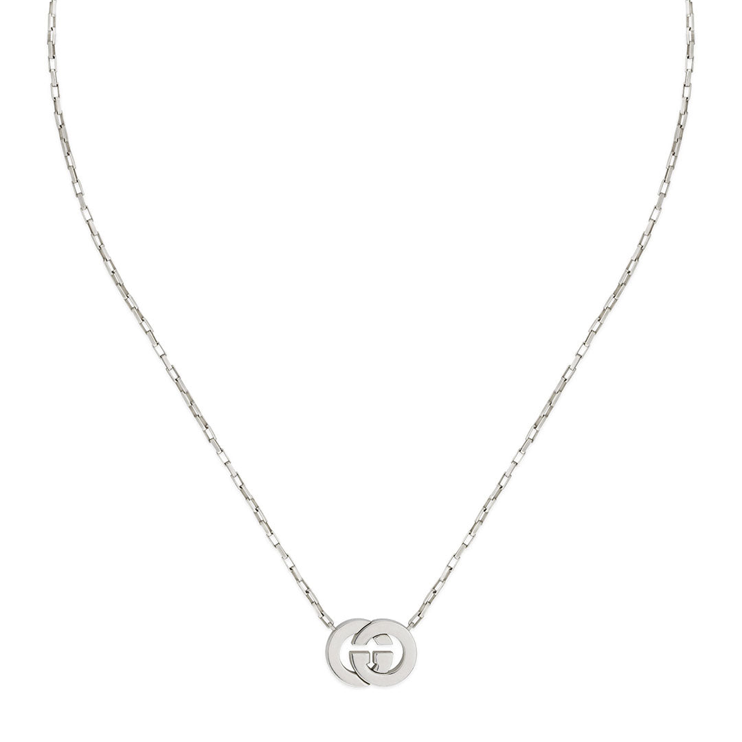 The Gucci Interlocking G Sterling Silver Necklace Pendant from GUCCI Fine Jewellery features a delicate 925 silver chain with a small, round pendant showcasing interlocking "G" letters at the center.
