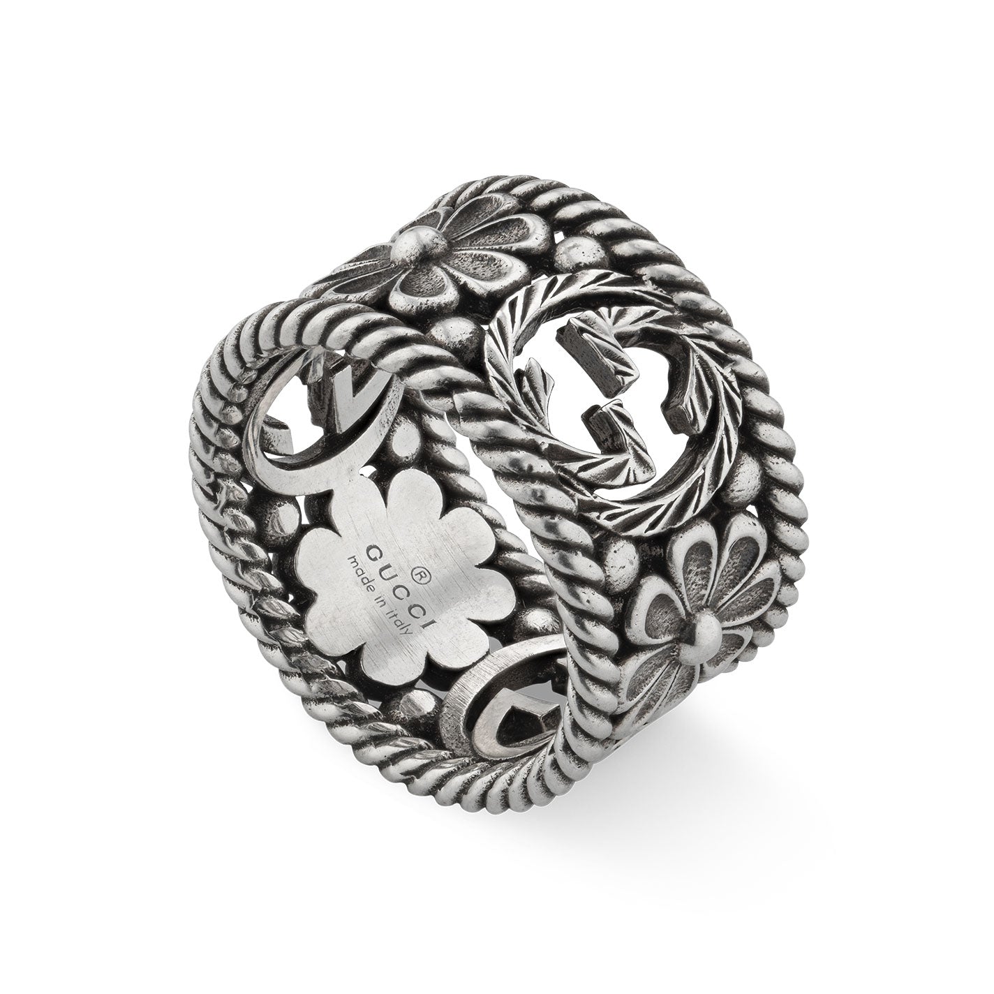 The Gucci Interlocking G Sterling Silver Ring by GUCCI Fine Jewellery features intricate floral and leaf designs, with embossed and cut-out patterns along the band. A prominent flower motif at the center highlights its elegant craftsmanship. Inside, a discreet logo insignia signifies that it is "Made in Italy.