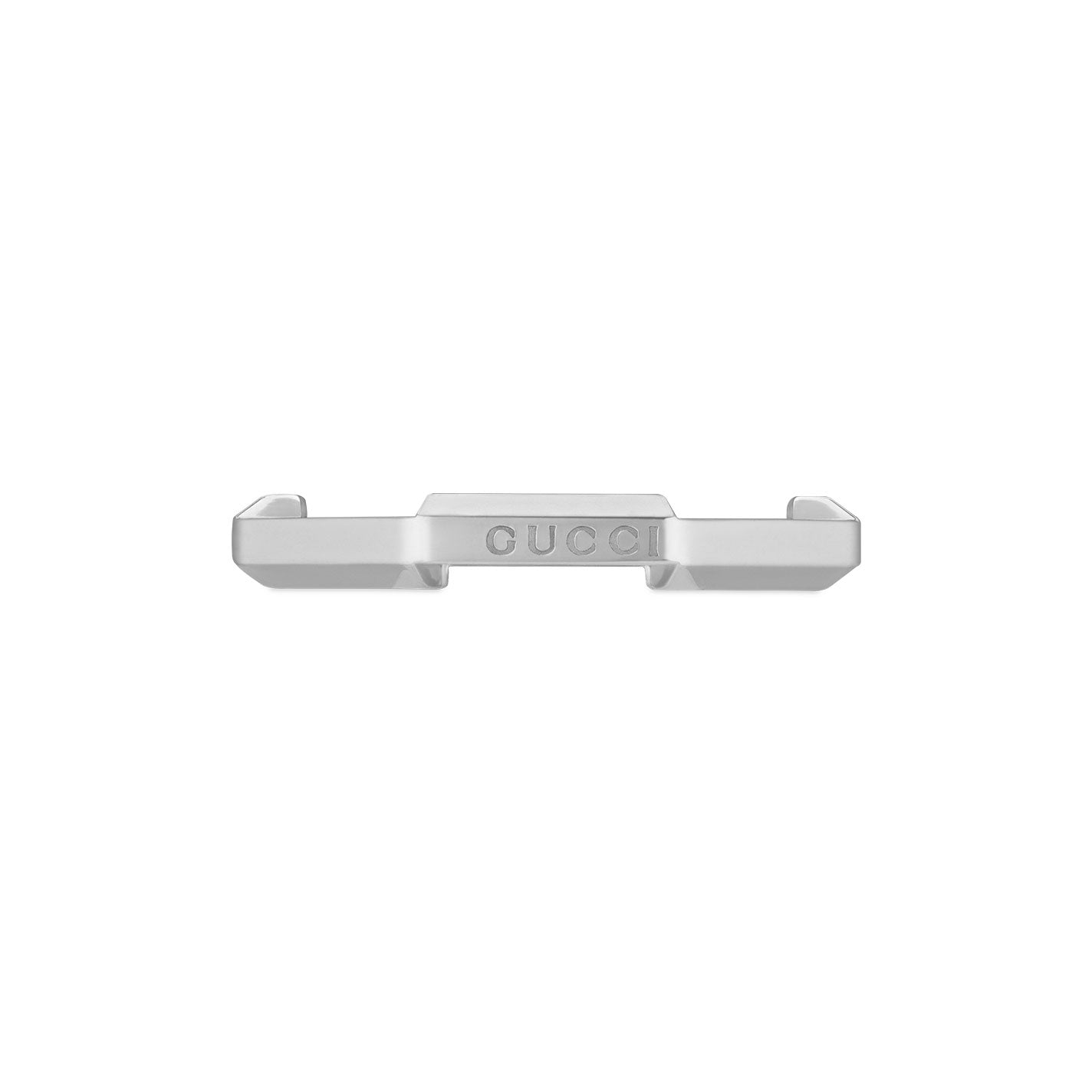 A close-up of a reflective silver metal piece prominently displaying the word "GUCCI" at its center. The item features a sleek and minimalist design, strongly resembling a component from the Gucci Link to Love collection, specifically the Mirrored 18K White Gold Ring. Its surface is both smooth and reflective.