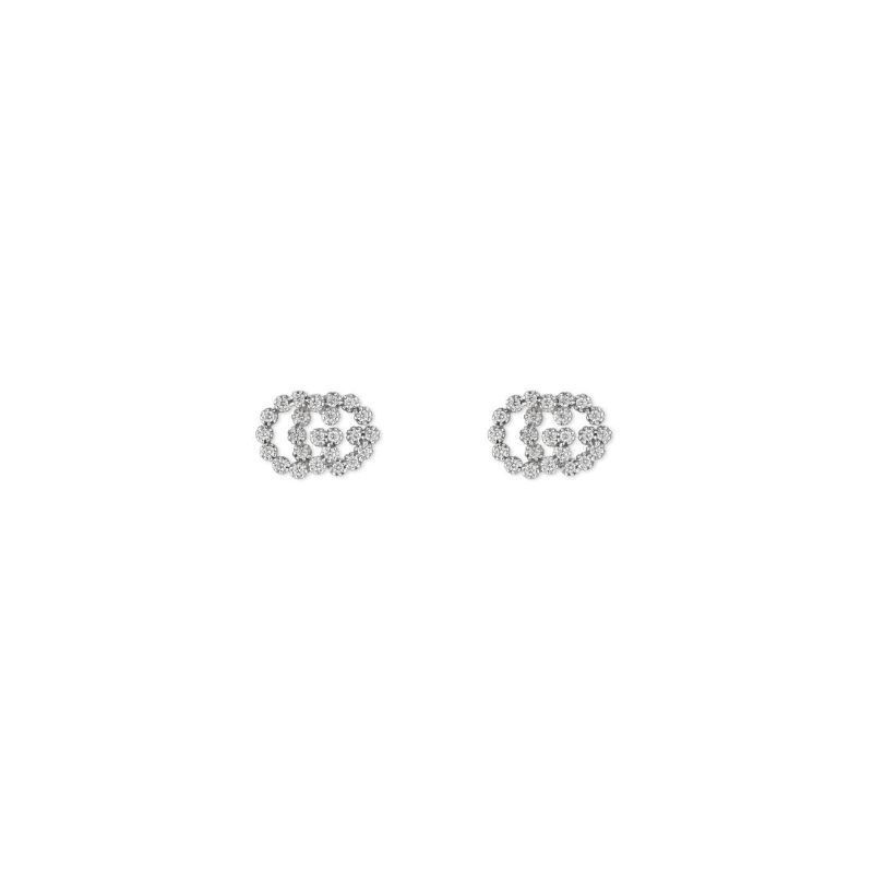 These exquisite Gucci GG Running earrings from GUCCI Fine Jewellery are flower-shaped studs crafted from 18K white gold, featuring intricate detailing. Each earring showcases a circular design adorned with small sparkling diamonds, set against a plain white background.