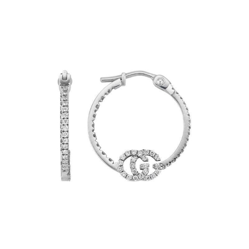 Introducing the Gucci GG Running 18K White Gold Diamond Hoop Earrings from GUCCI Fine Jewellery. These elegant earrings feature a decorative "G" encrusted with diamonds on one hoop, while small diamonds embellish both hoops in a sleek design that displays one earring from the side and the other from the front, enhancing their timeless beauty.