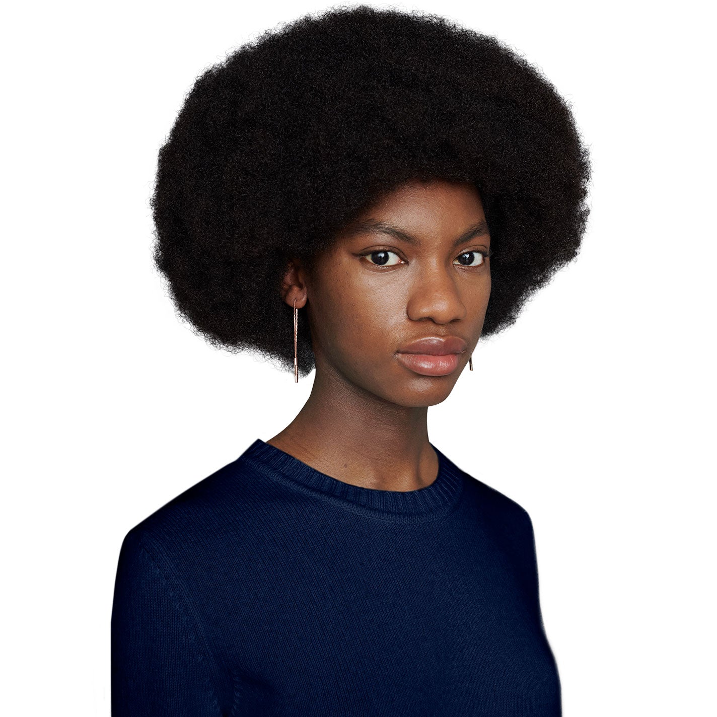 A person with a natural afro hairstyle wears a navy blue sweater and Gucci Link To Love 18K rose gold chain drop earrings featuring the "Gucci" bar, set against a plain white background.