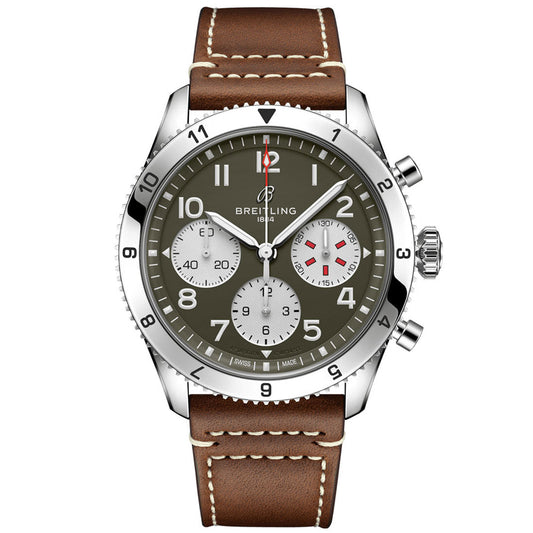 Introducing the BREITLING Classic AVI Chronograph 42 Curtiss Warhawk by Breitling: a pilot's watch featuring a green dial with white hour markers, complemented by silver subdials. It comes with a brown leather strap accented with white stitching and is paired with a silver bezel. Drawing inspiration from the Curtiss P-40 Warhawk, this timepiece is equipped with three subdials and two pushers on the side.